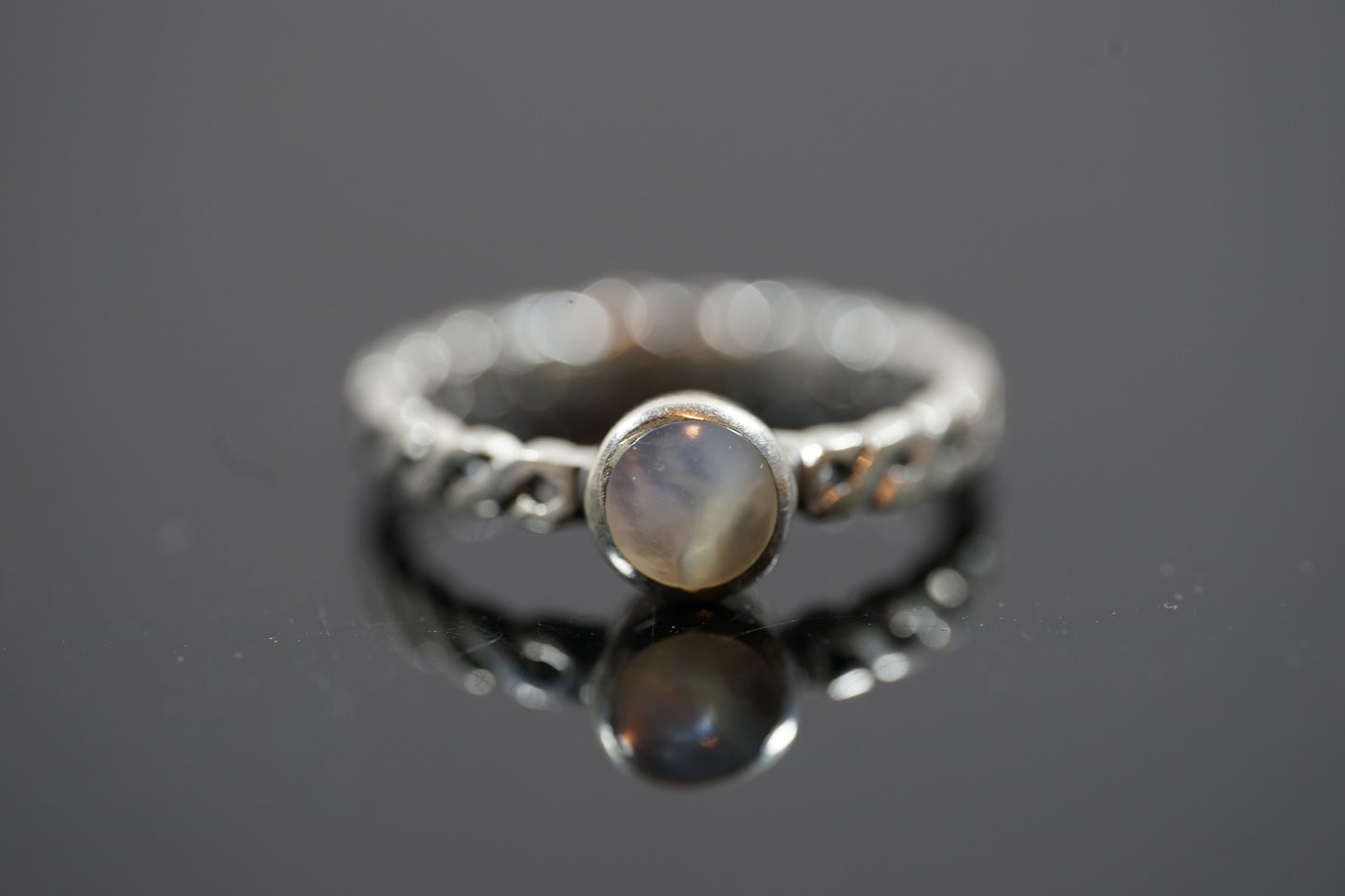 Silver Ring With Round Gemstone And Braided Band Design